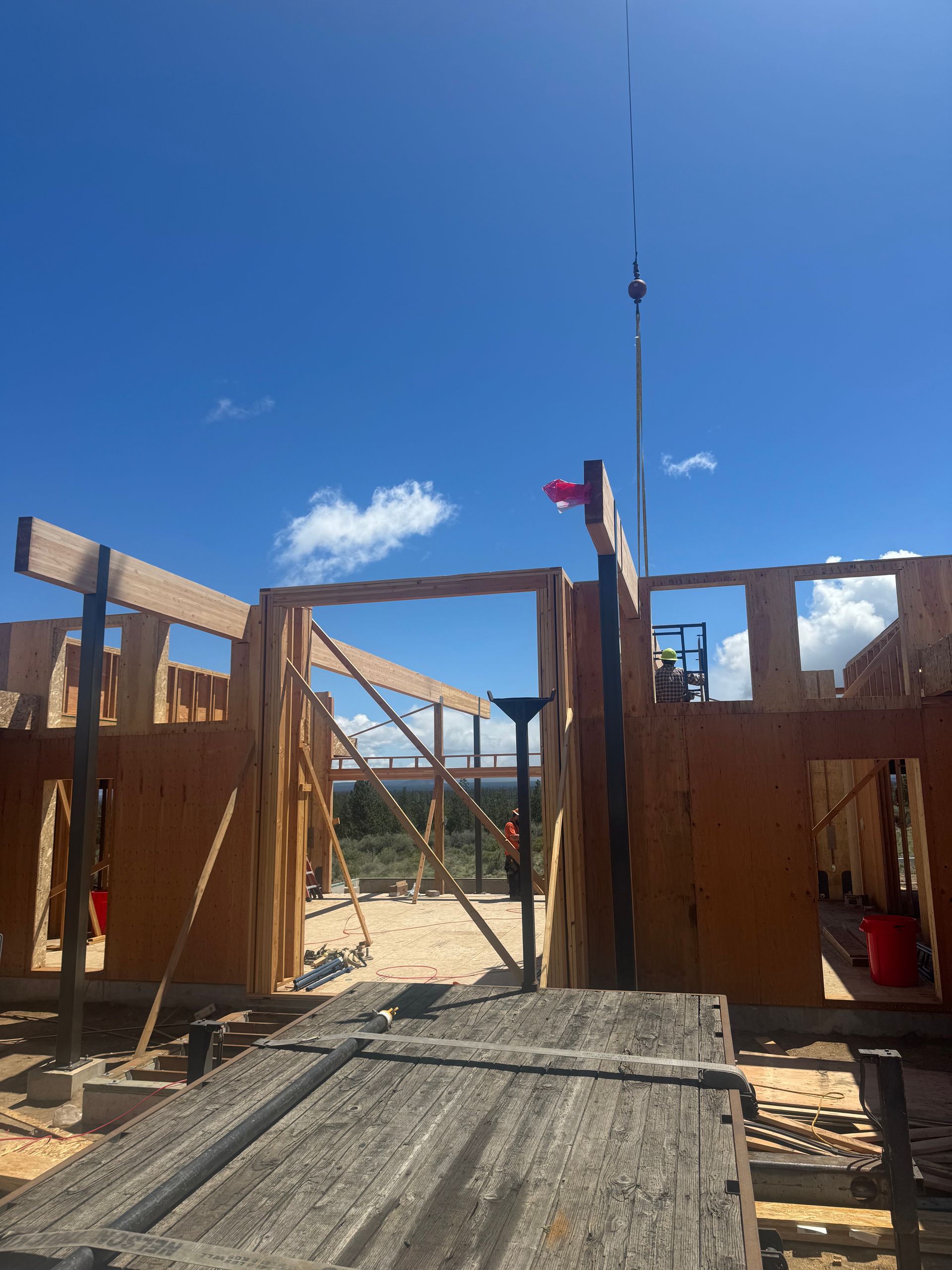 A wooden structure is being built with a crane in the background.