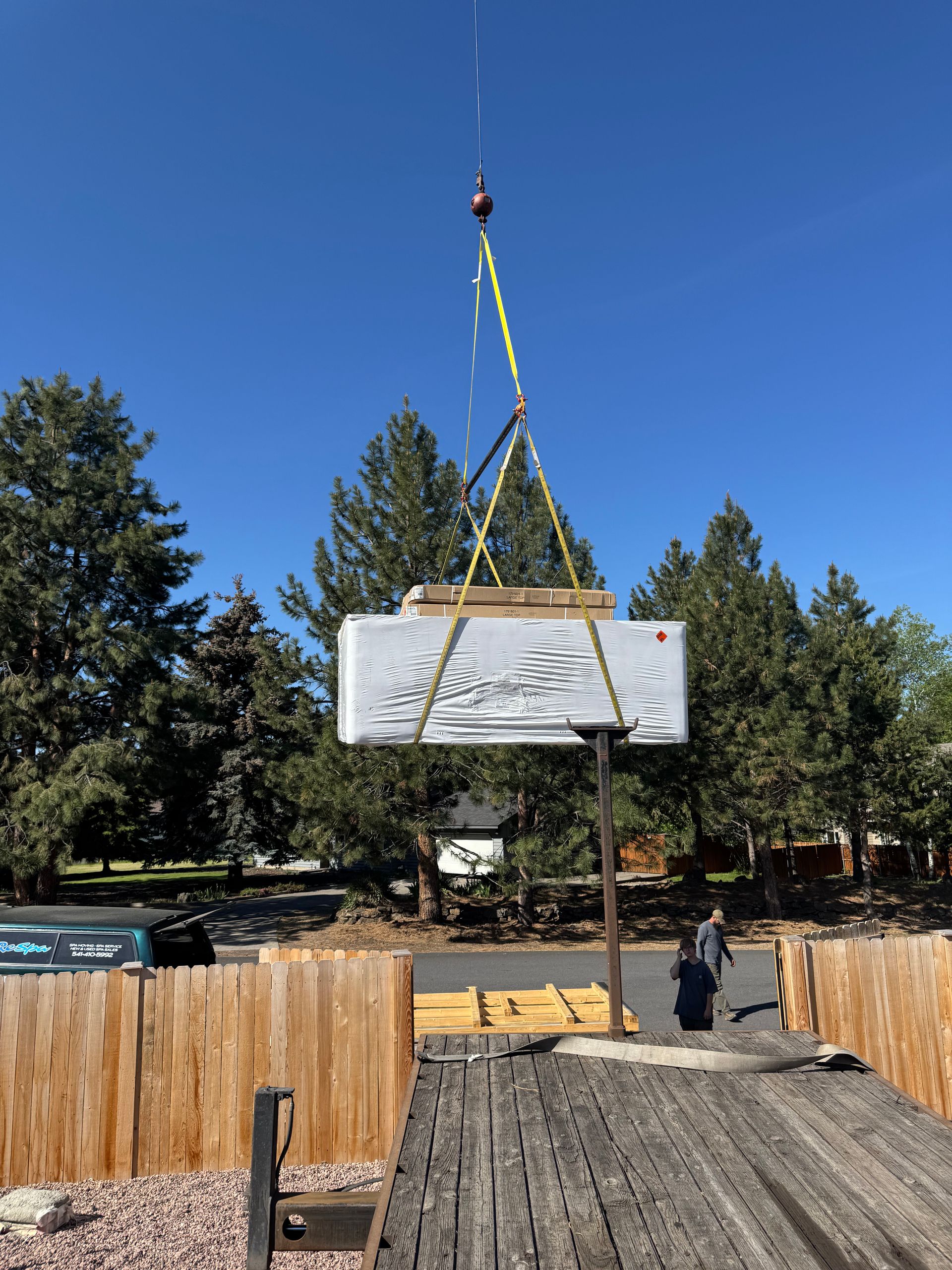 A large piece of wood is being lifted by a crane.