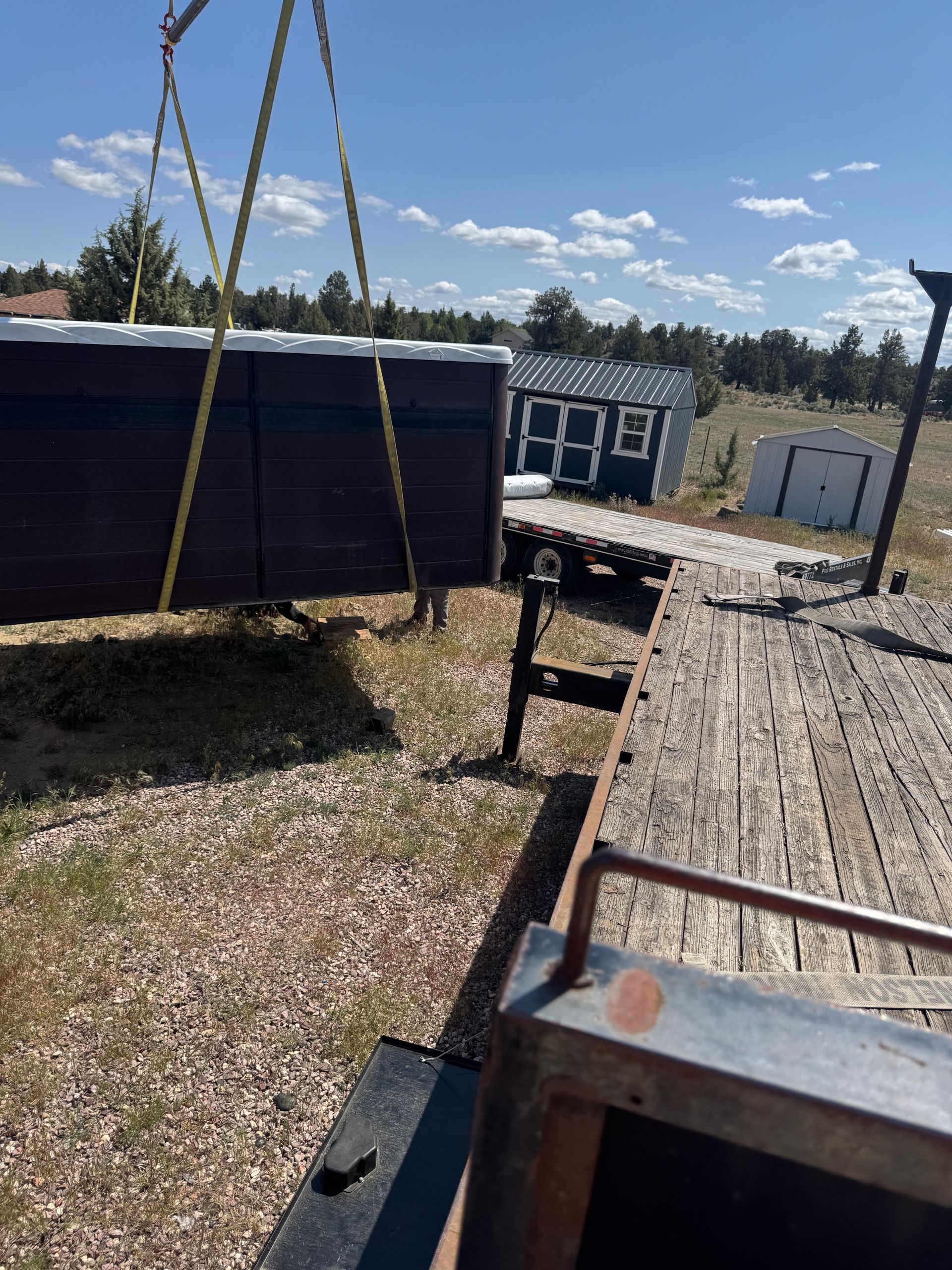 A large piece of wood is being lifted by a crane.
