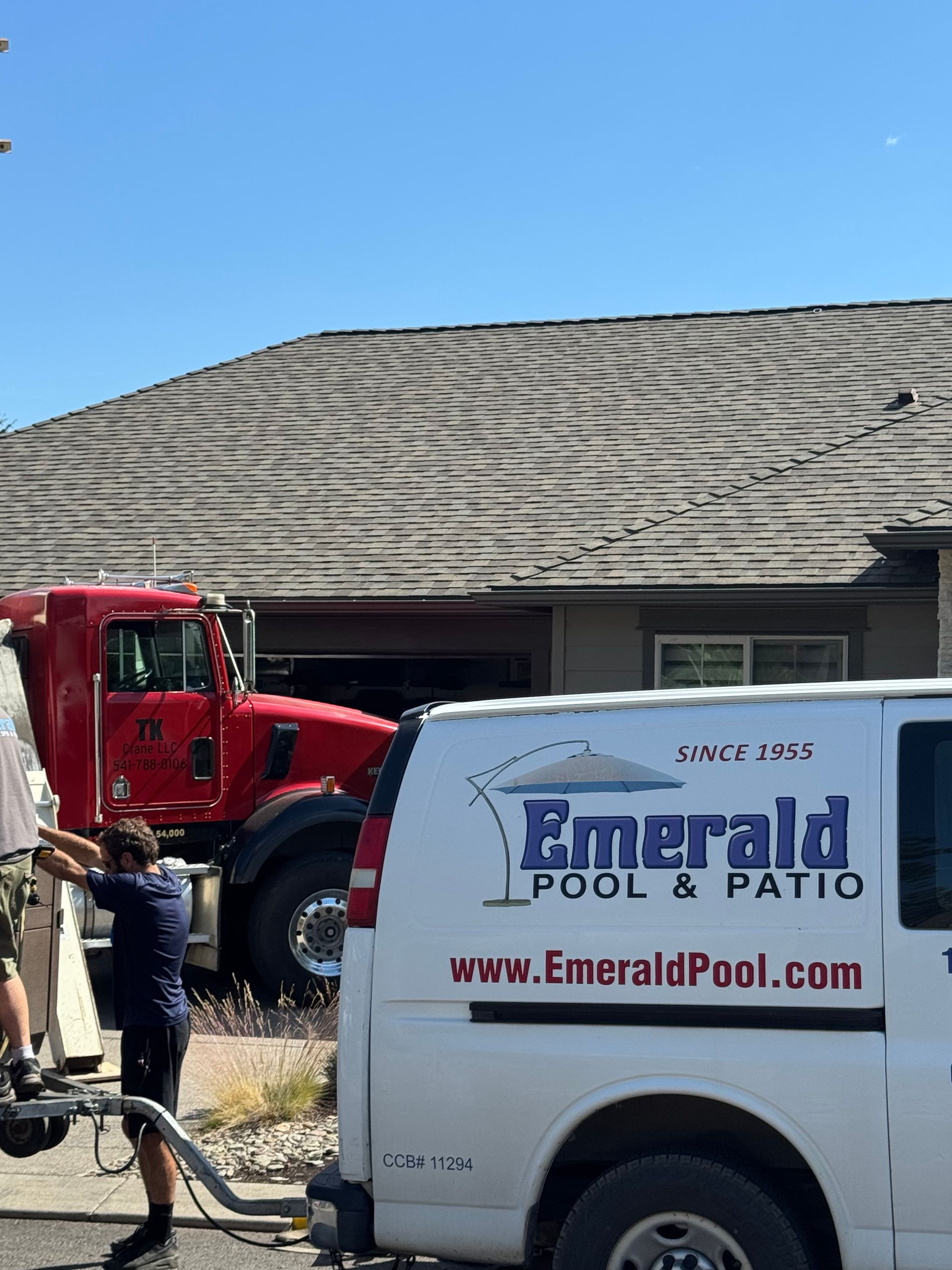 An emerald pool and patio van is parked in front of a house.
