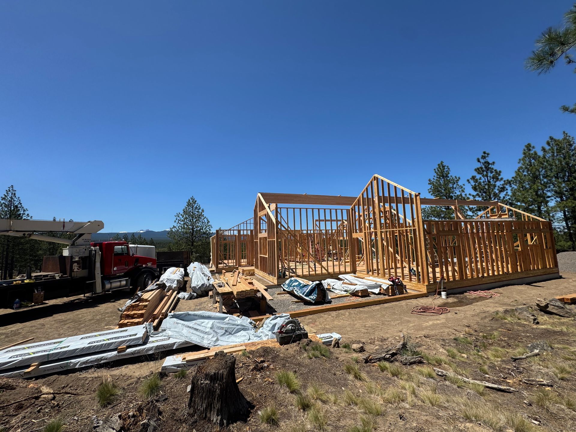 A house is being built on a hill with a crane in the background.