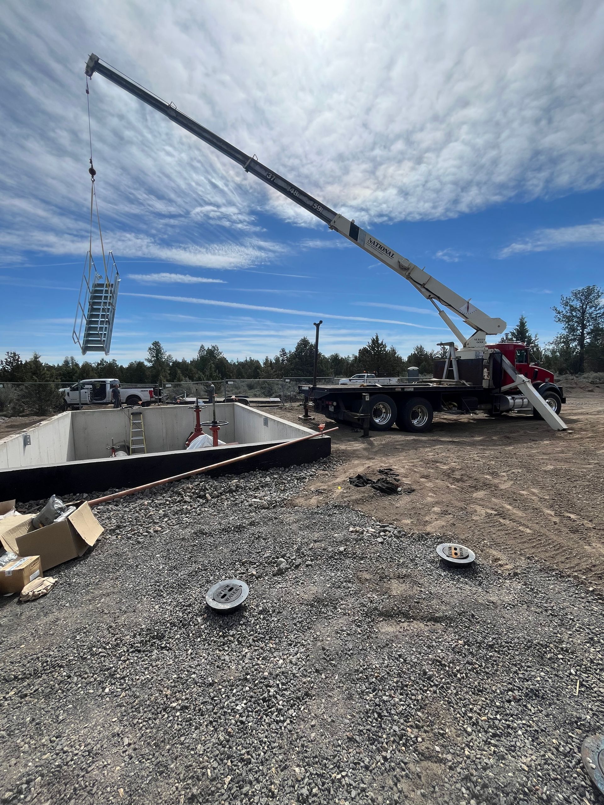 A crane is lifting a piece of concrete into a pool.
