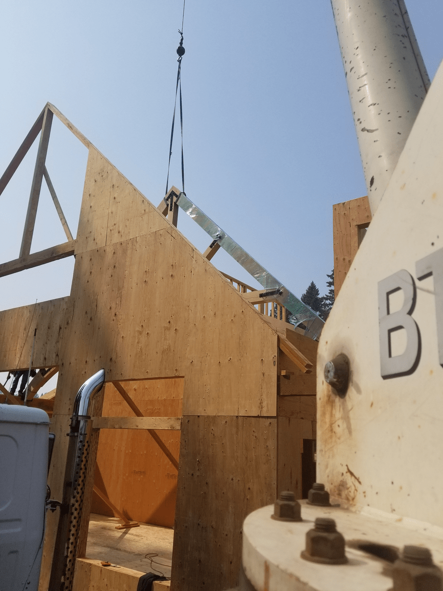A crane is lifting a piece of wood with the letter b on it