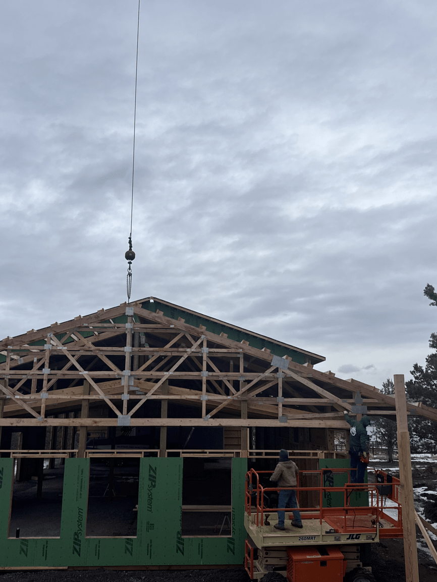 A house is being built with a crane on top of it.