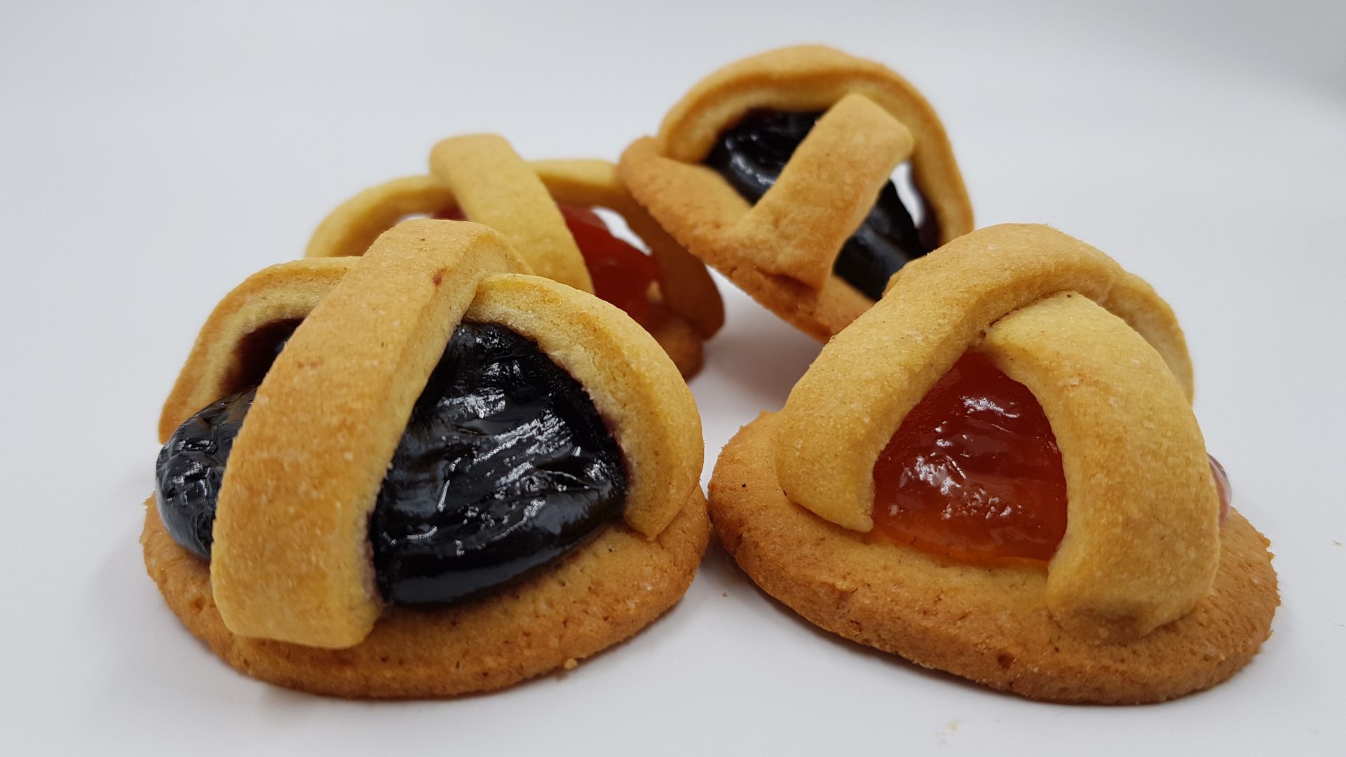Tre biscotti con diversi tipi di marmellata sopra