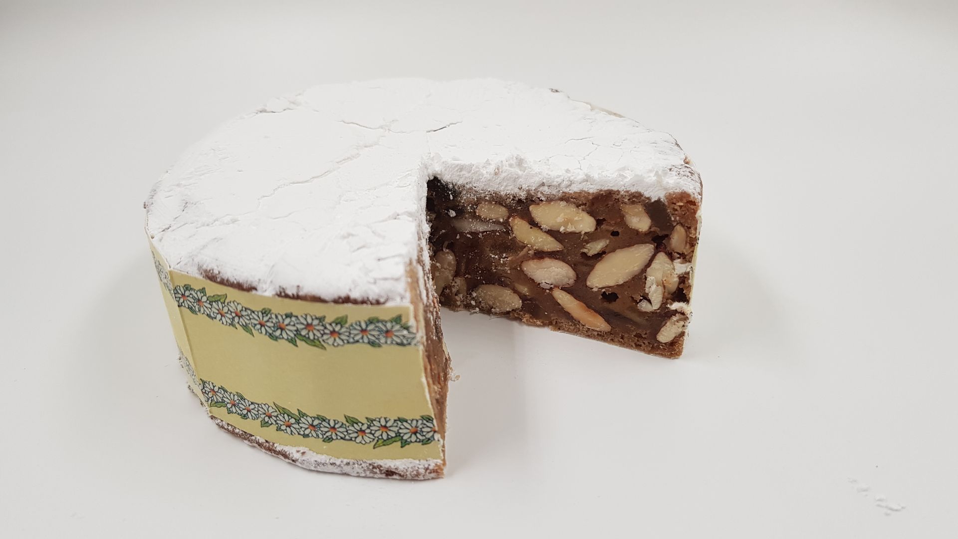 Una torta da cui è stata staccata una fetta è ricoperta di zucchero a velo.