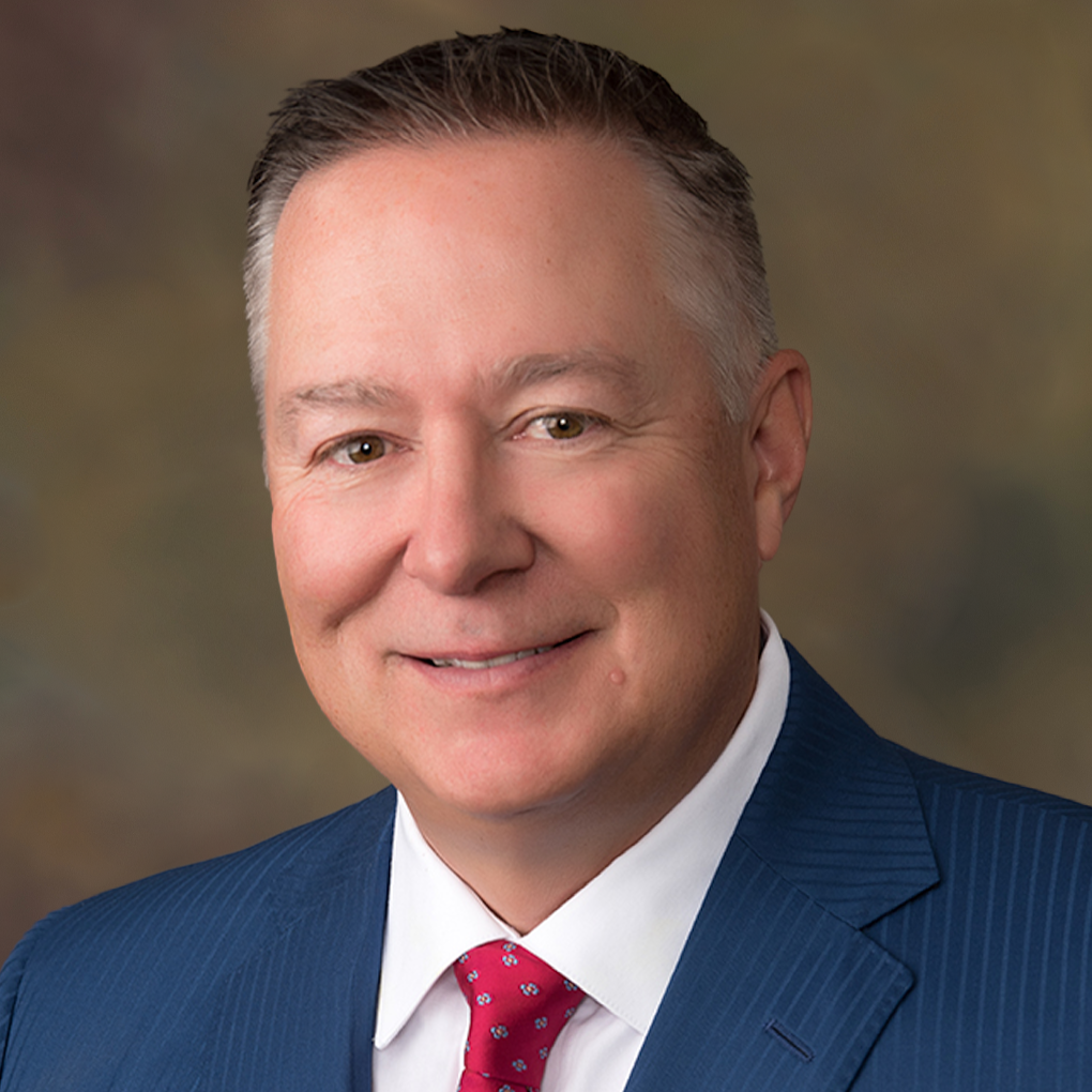 A man in a suit and tie is smiling for the camera.