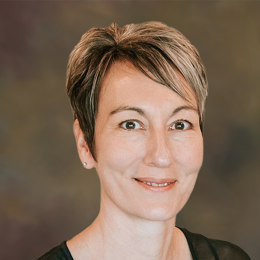 A woman with short hair is smiling and wearing a black shirt.