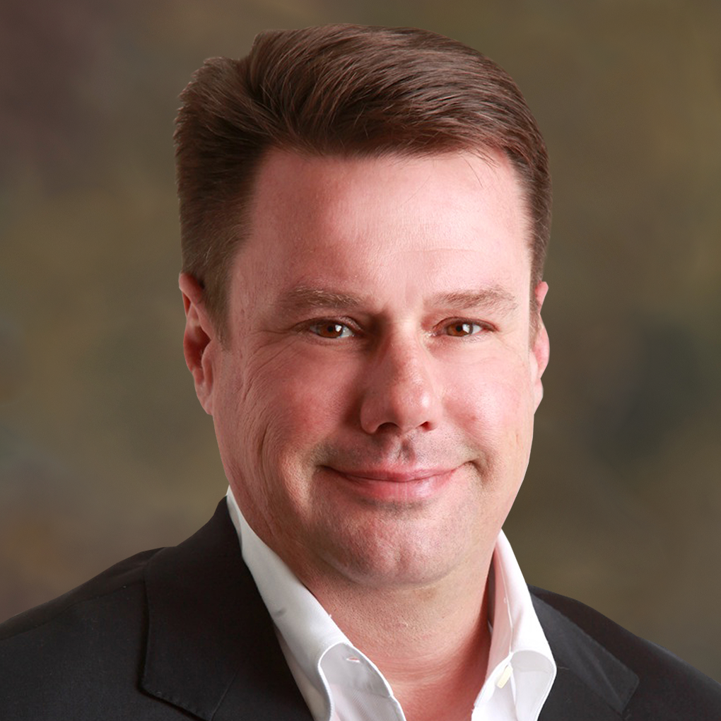 A man in a suit and white shirt is smiling for the camera