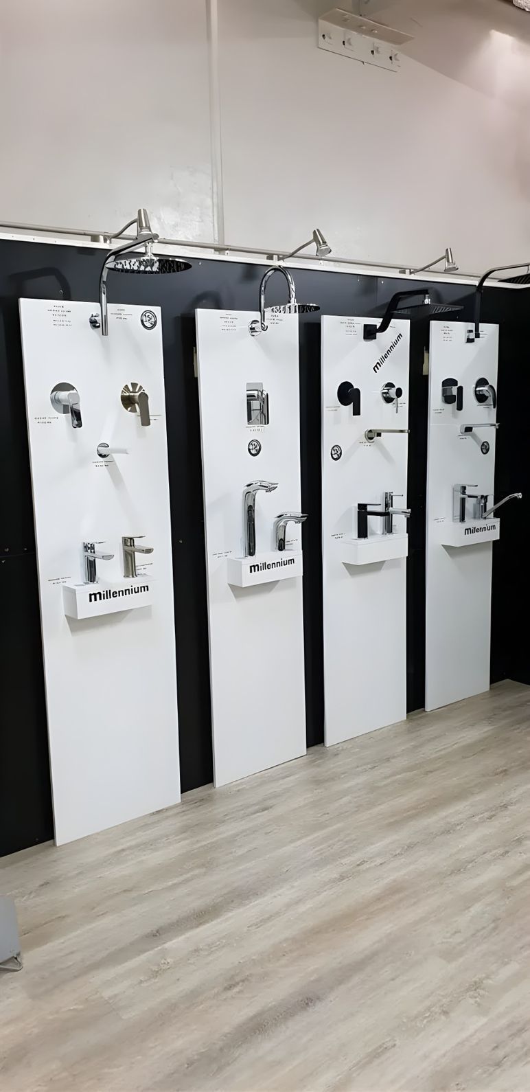 Bathroom Fixtures Displayed on White Panels in a Showroom. the Panels Are Arranged in a Row on a Wood-look Floor — North Coast Tiles in Maclean, NSW