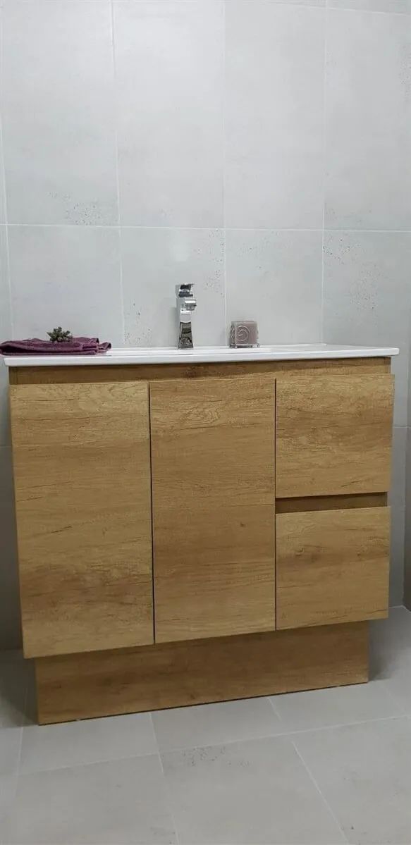 Wooden Bathroom Vanity With a White Countertop and Faucet. the Vanity Has Two Doors and a Drawer. White Tile Walls and Floor — North Coast Tiles in Iluka, NSW