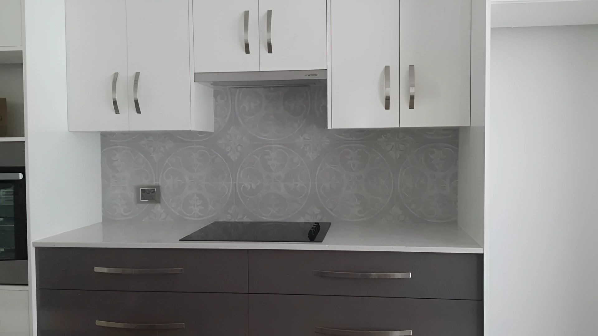 Modern Kitchen With White Upper Cabinets, Dark Brown Lower Cabinets, Light Countertops, and a Gray Tile Backsplash — North Coast Tiles in Iluka, NSW