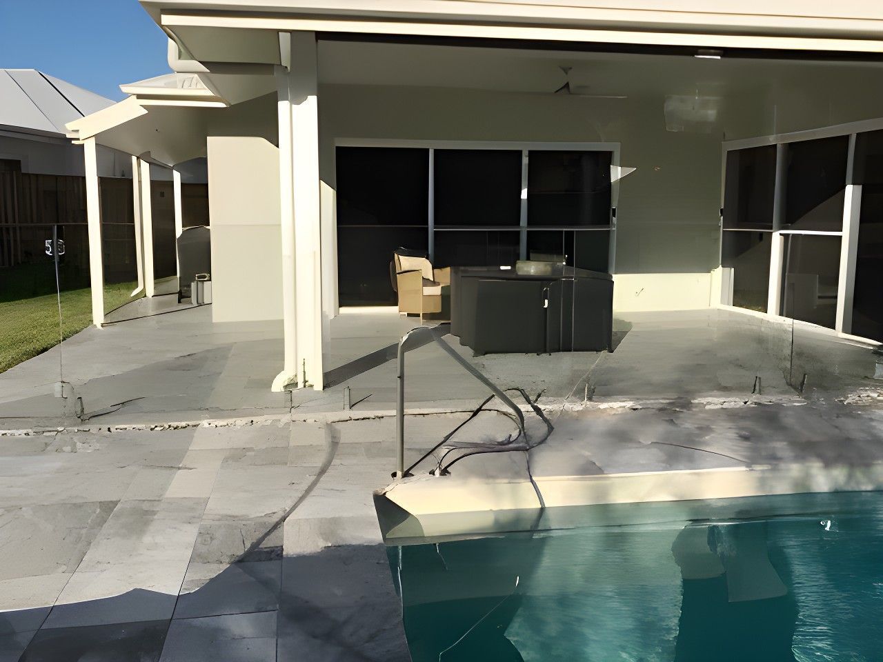 Backyard With a Pool, Patio, and House. Gray Tile Surrounds the Poo — North Coast Tiles in Grafton, NSW