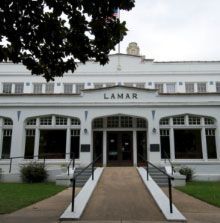 A large white building with stairs leading up to the entrance.