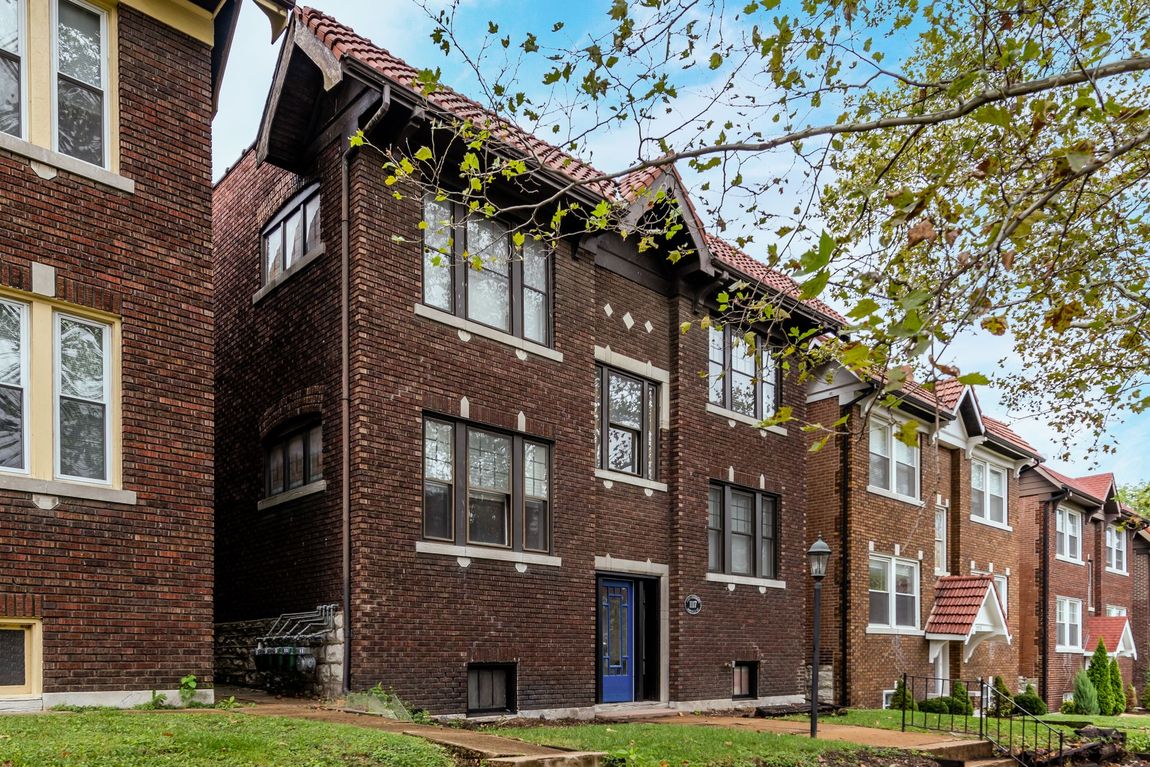 A row of brick apartment buildings with a blue door.