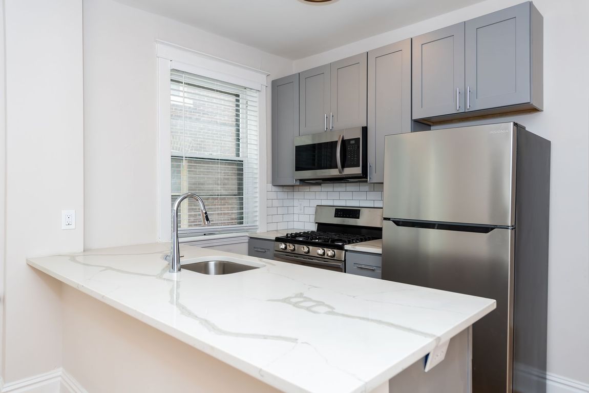 A kitchen with a stainless steel refrigerator , stove , sink and microwave.