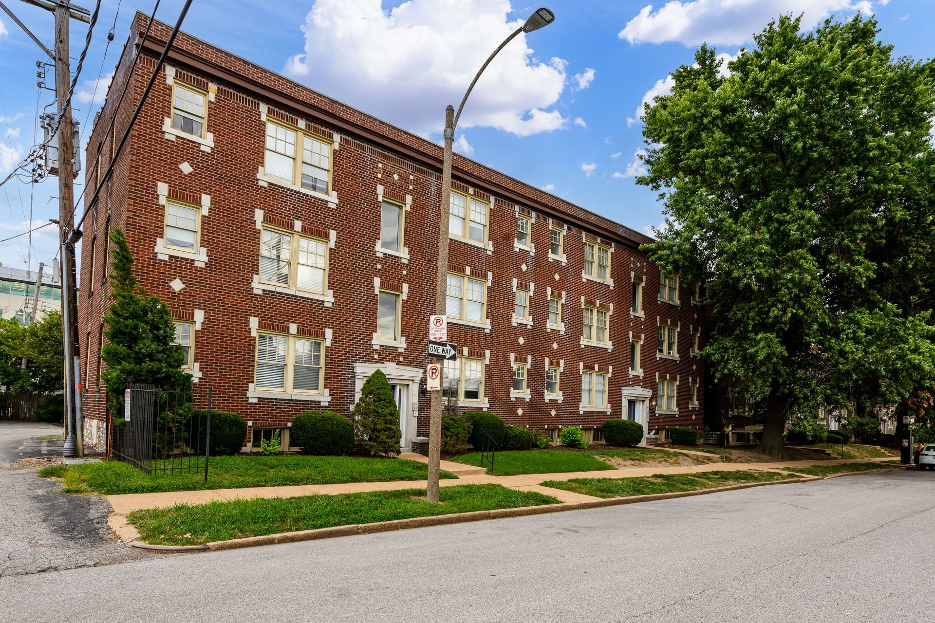 A large brick apartment building with a no parking sign in front of it