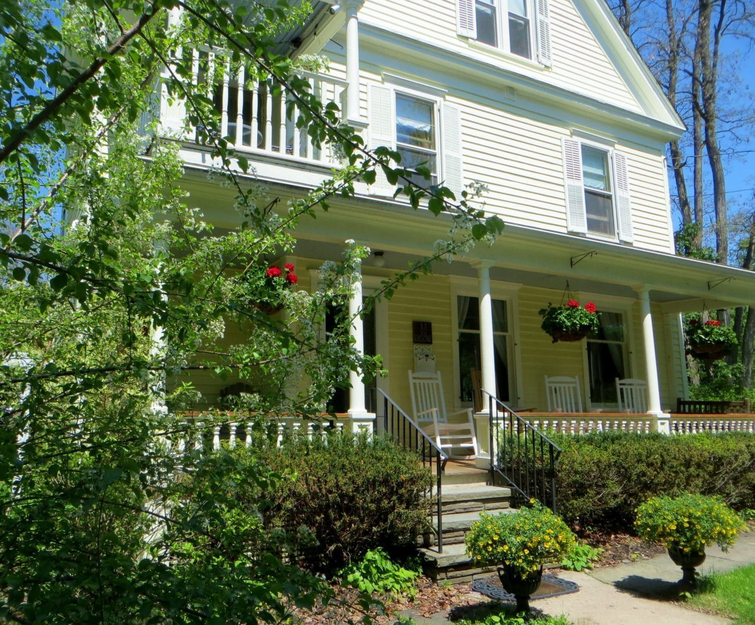 A large white house with a porch and stairs