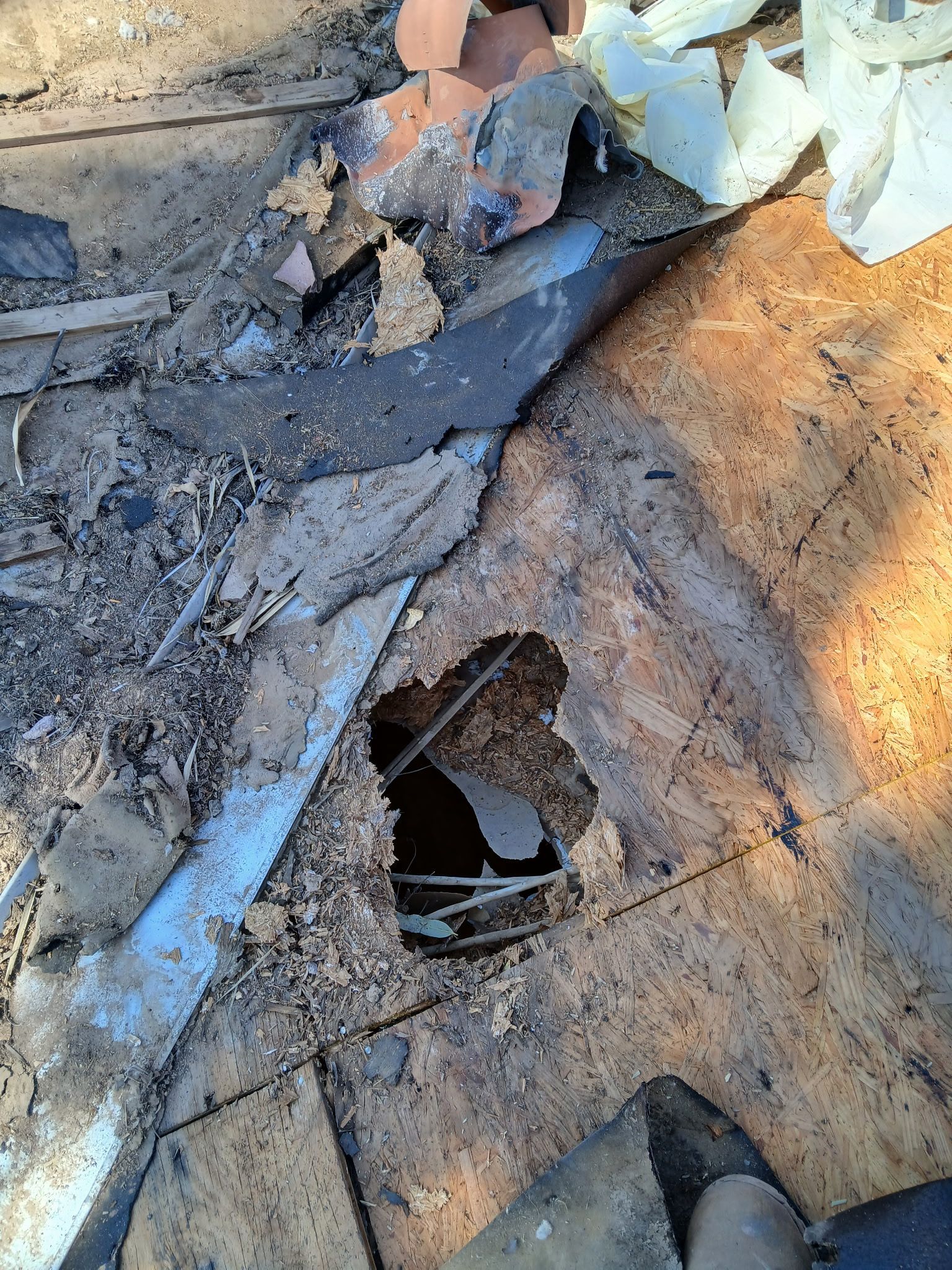 Damaged wooden surface with a hole, debris, and exposed interior.