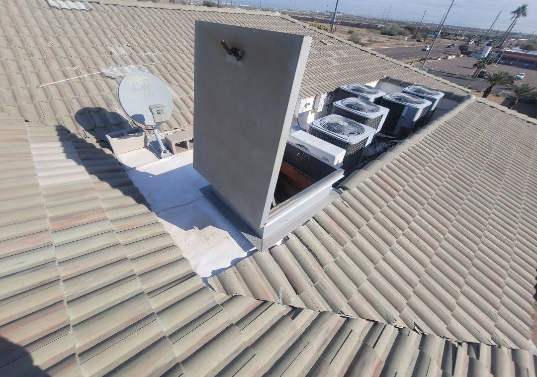 Roof with chimney, satellite dish, and air conditioning units.