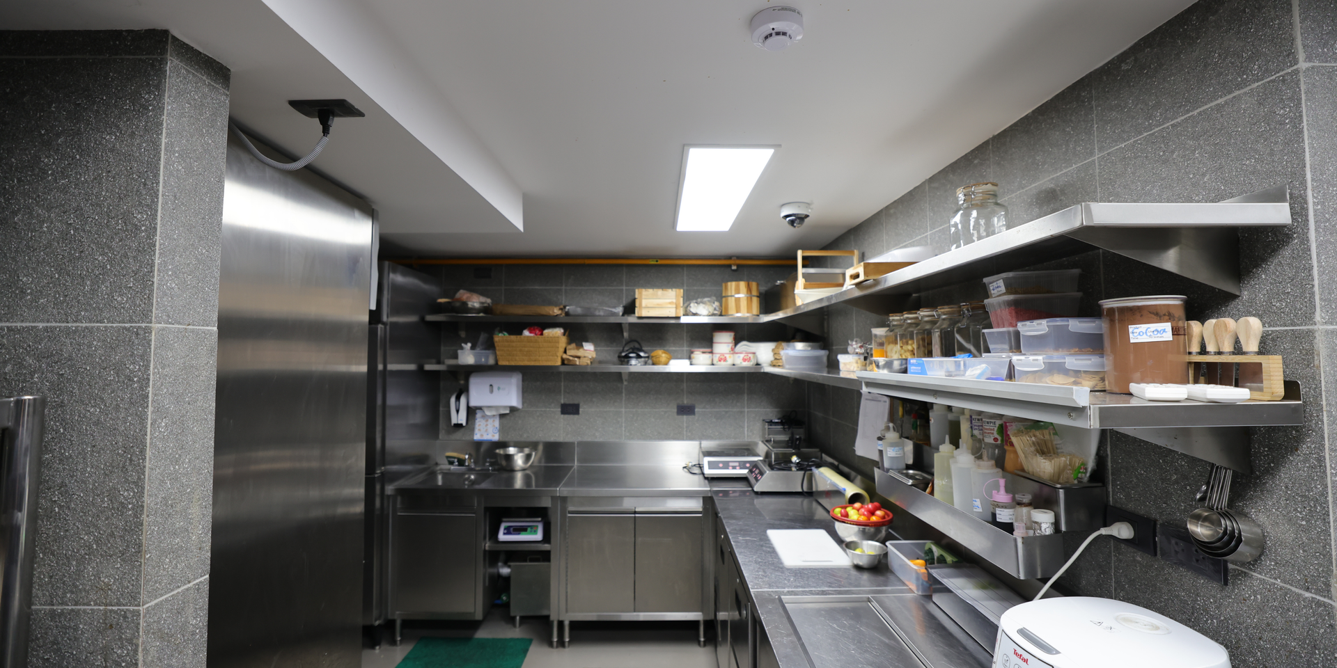 A commercial kitchen interior with stainless steel appliances and shelving.