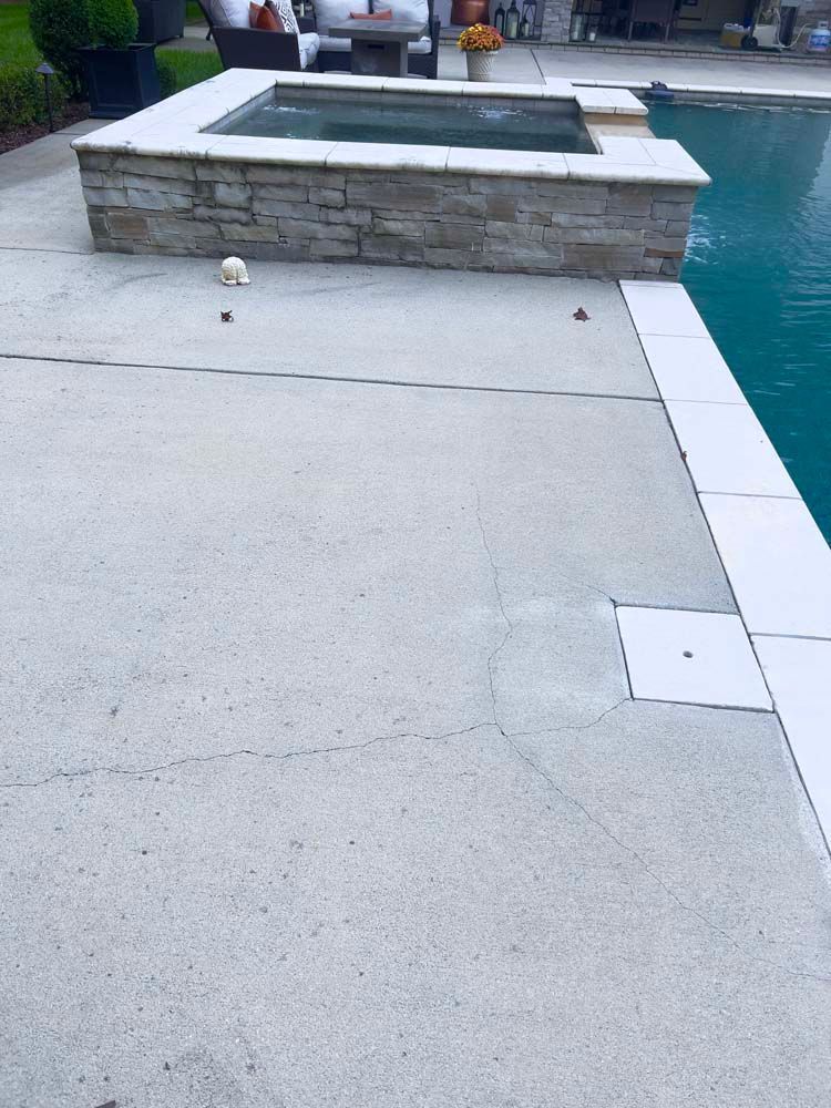 Concrete patio with a hot tub and pool.