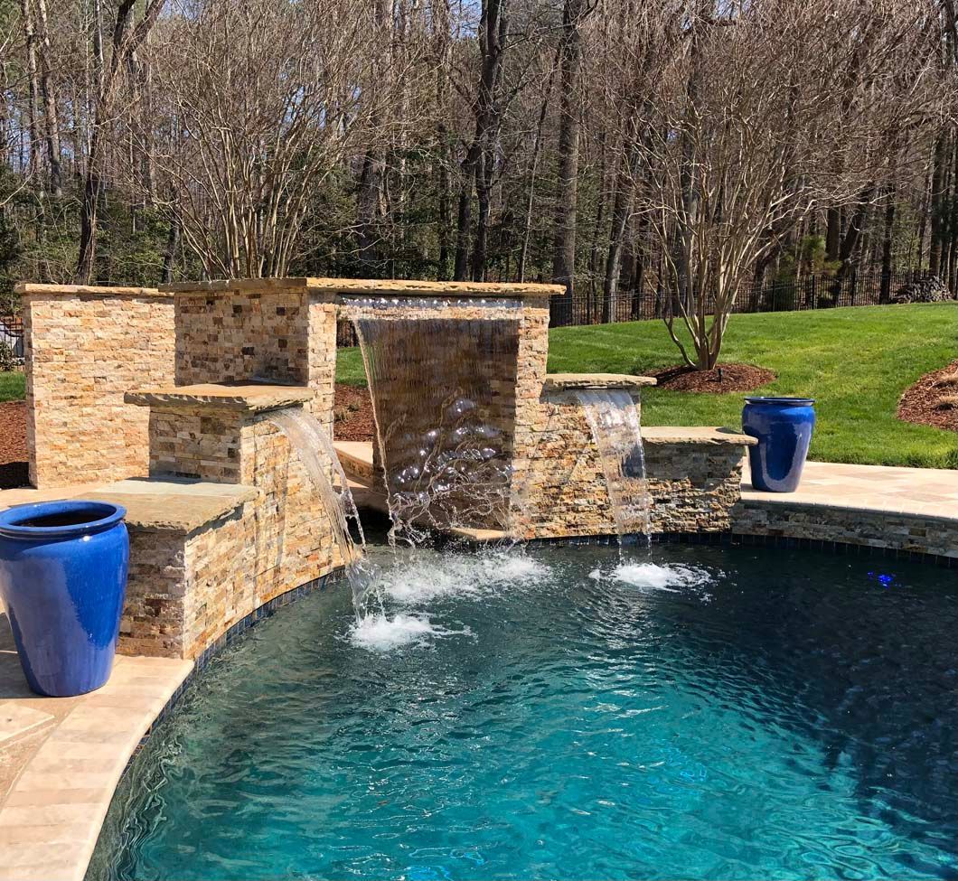 There is a waterfall in the middle of the pool.