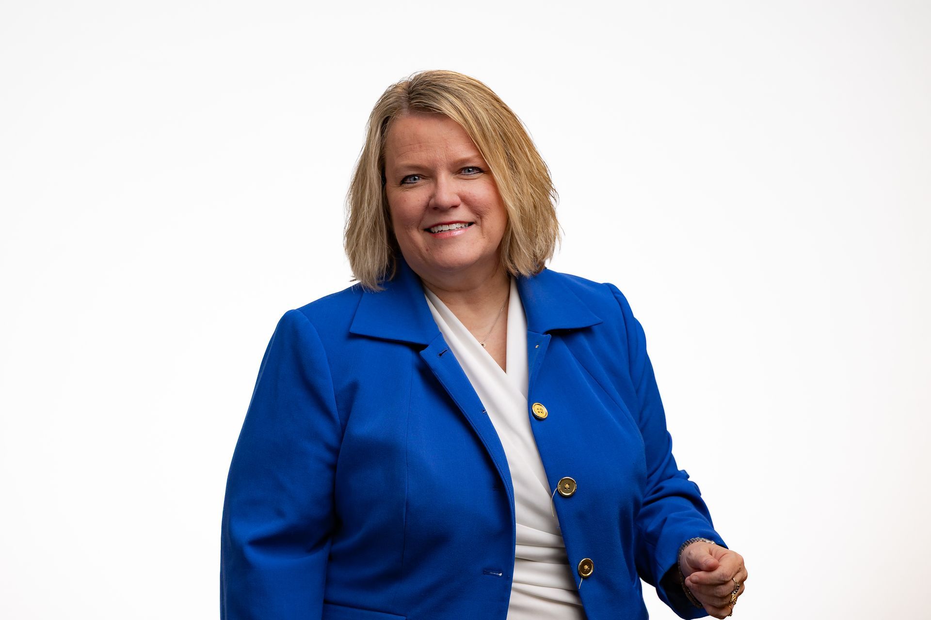 Dr. Celina in a blue blazer smiles at the camera against a white background.
