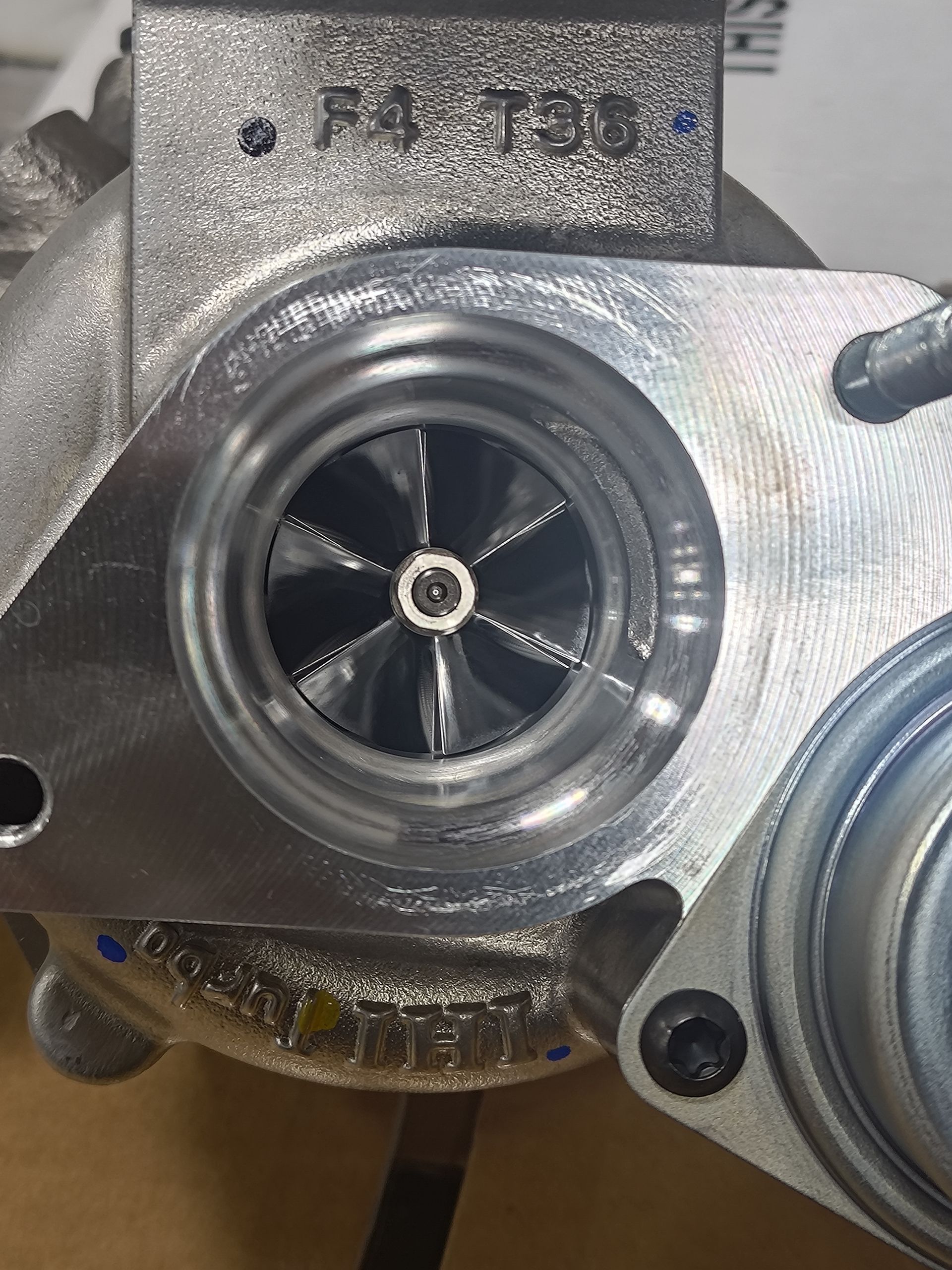 Close-up of a silver turbocharger with black fan blades, showing the impeller | La Saga Auto