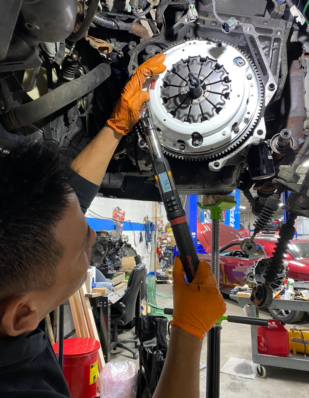 Mechanic tightening a clutch with a torque wrench in a car repair shop | La Saga Auto