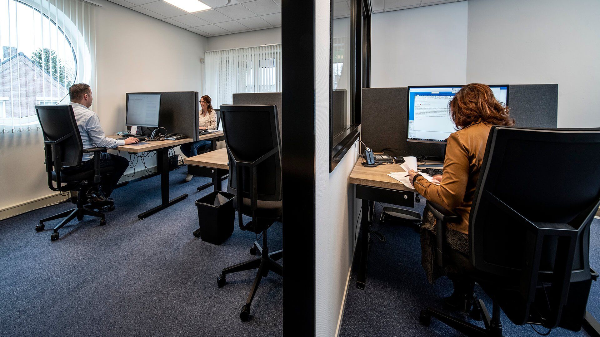 Een man en een vrouw zitten aan een bureau in een kantoor.