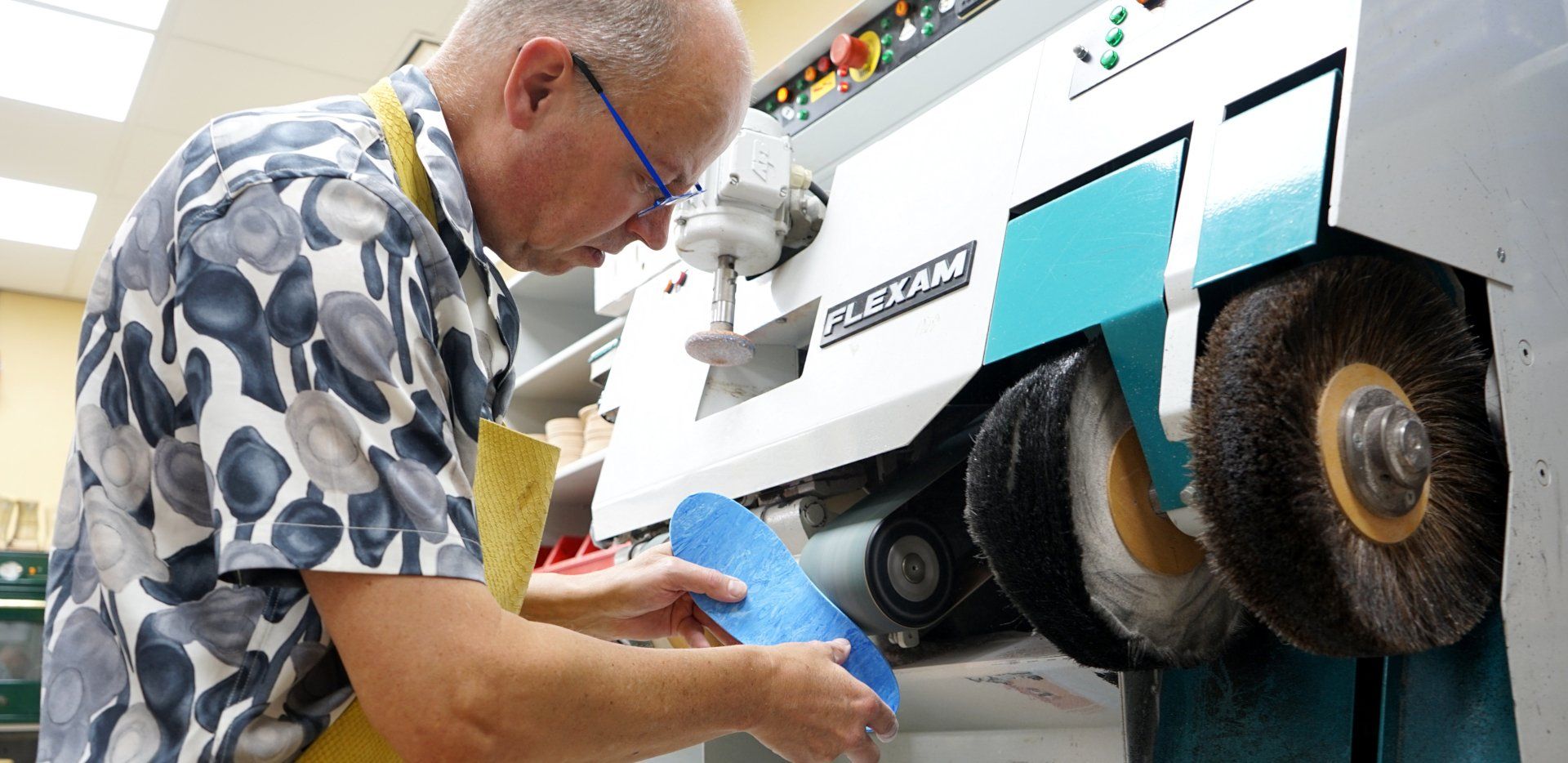 Een man poetst een schoen met een machine.