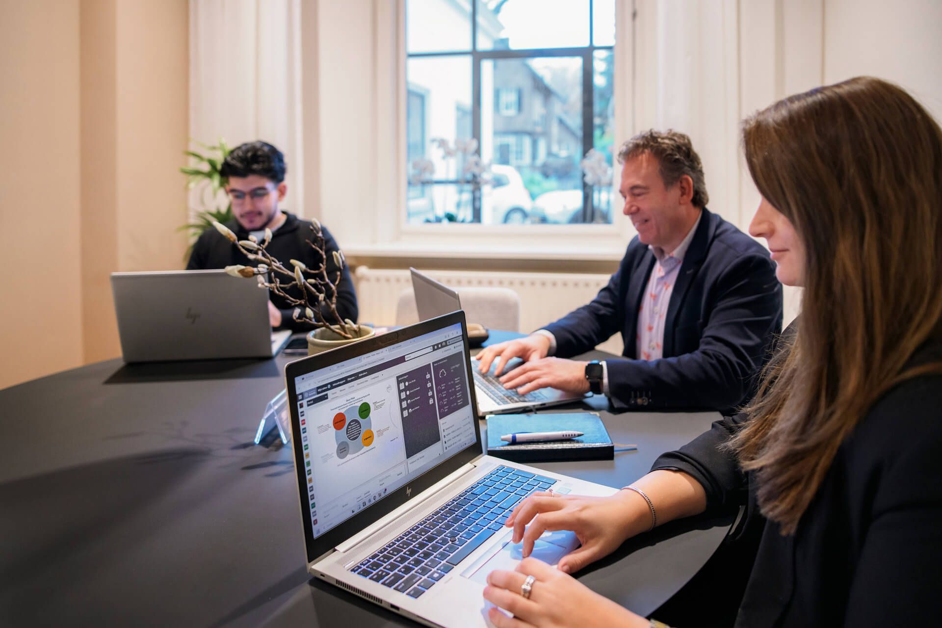 Twee vrouwen zitten aan een tafel en kijken naar een vel papier.