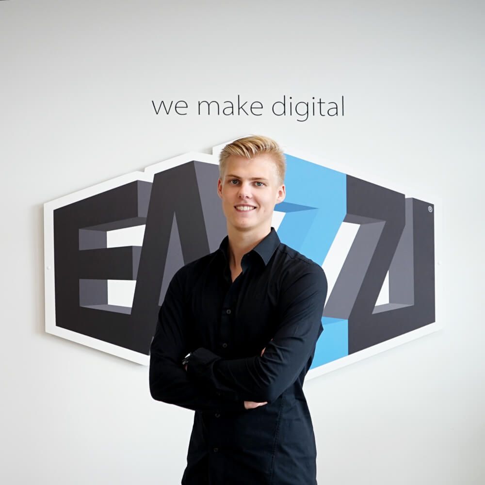 Kevin staat voor het logo van EAZZI met slogan We make digital