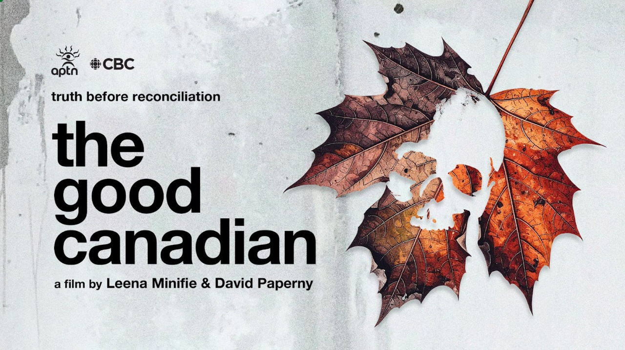 An upside-down broken and decaying red, orange, and brown maple leaf with a centered hole in the leaf in the shape of a skull against a gritty grey background.