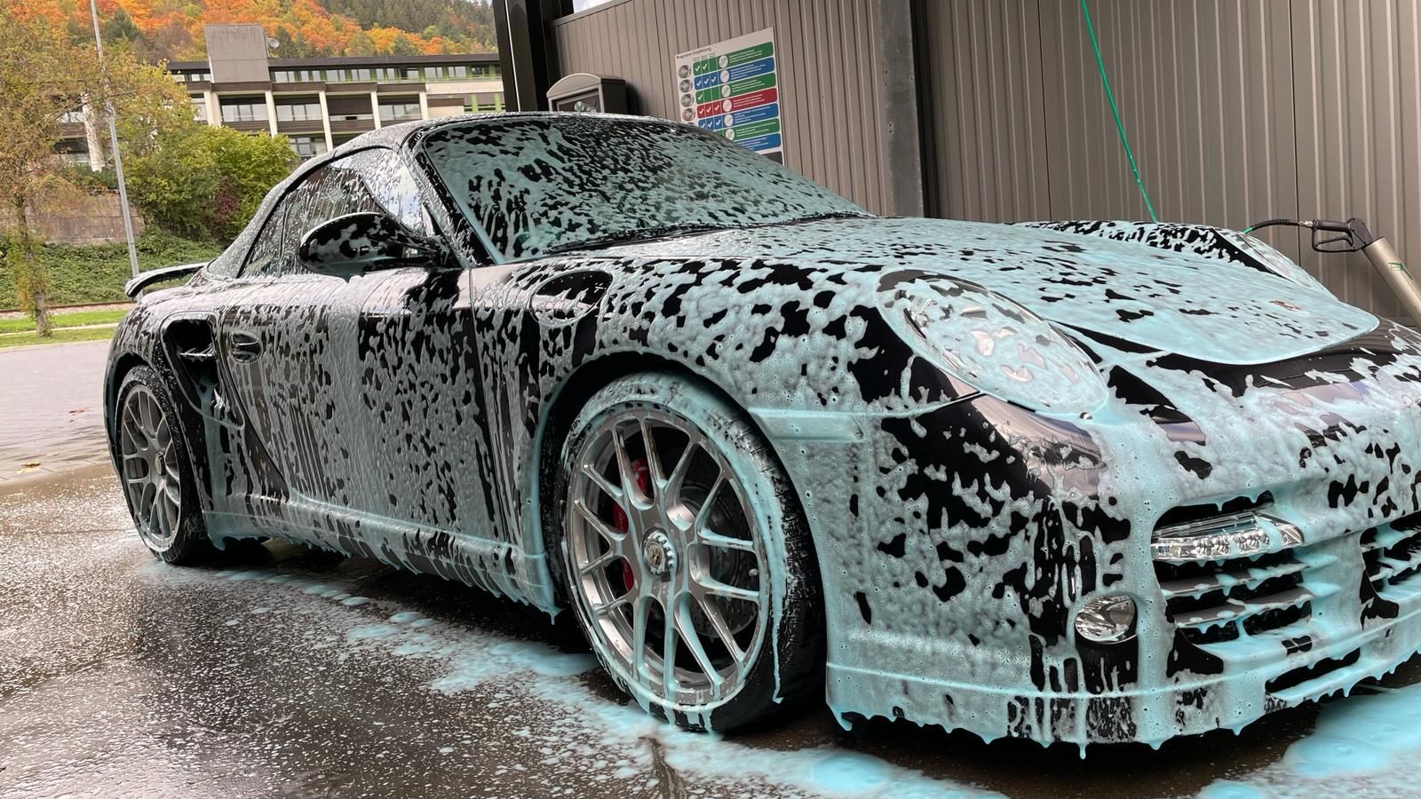 Ein Auto wird in einer Autowaschanlage mit Schaum bedeckt.