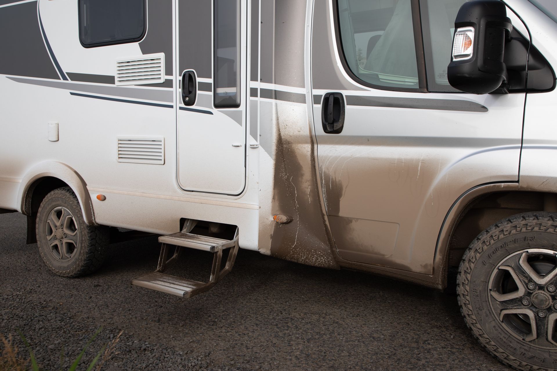 Ein graues Auto steht auf einem gefliesten Boden in einer Garage.