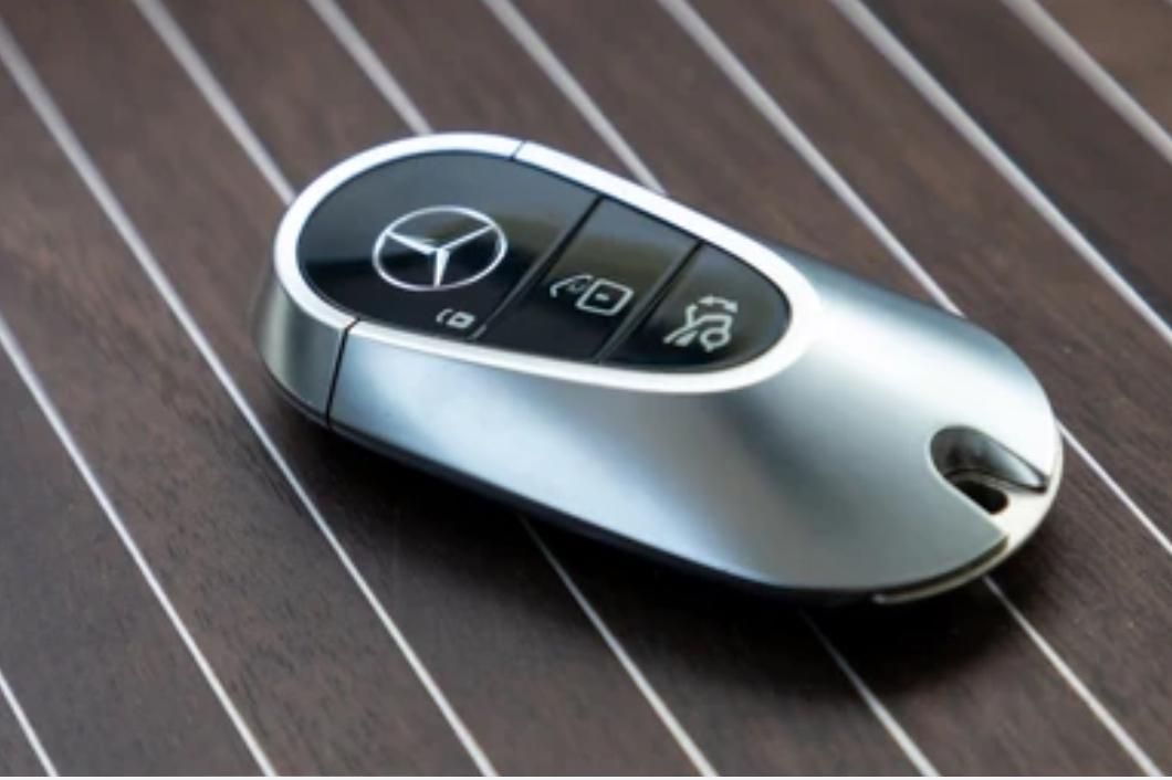 Ein Mercedes-Schlüsselanhänger liegt auf einer Holzoberfläche