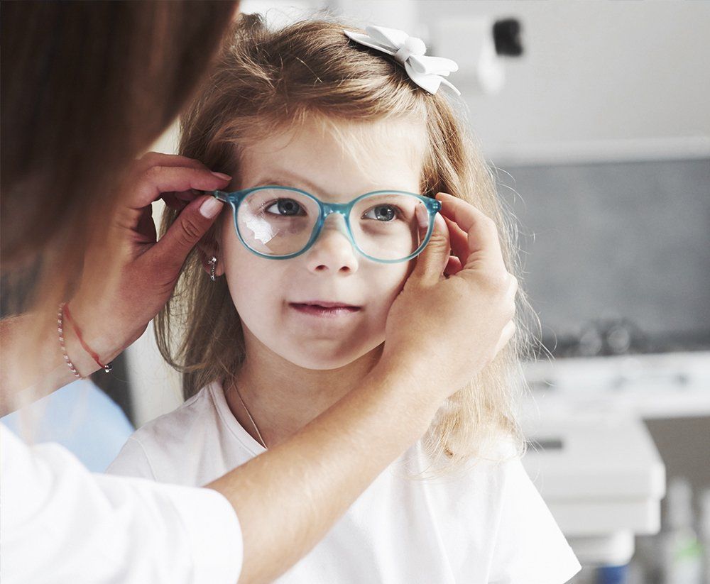 Doctor Giving the Child New Glasses — Taylor, TX — Optical Design