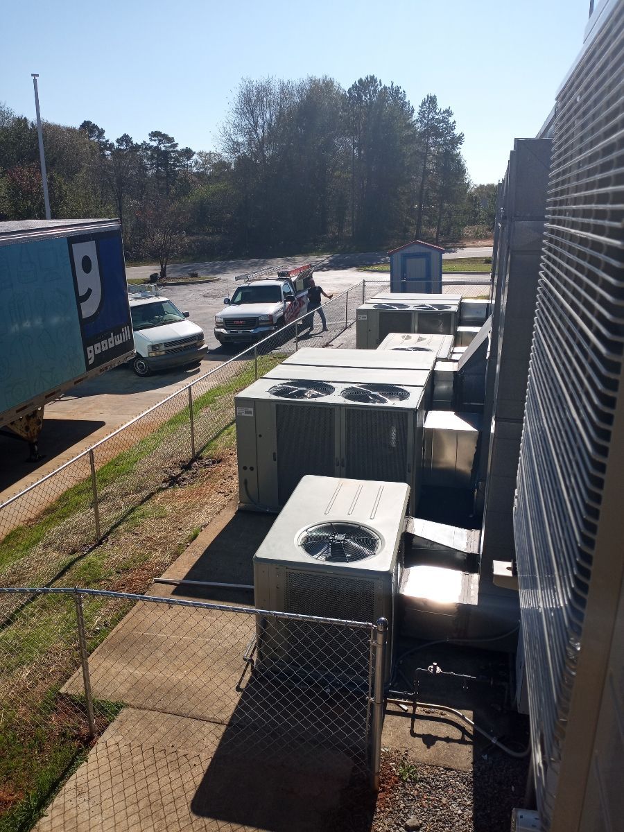 A truck with the letter g on it is parked next to a row of air conditioners.