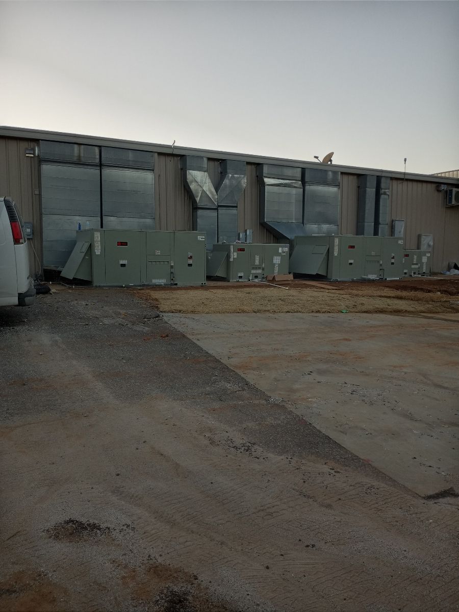A car is parked in front of a large building with a lot of windows.