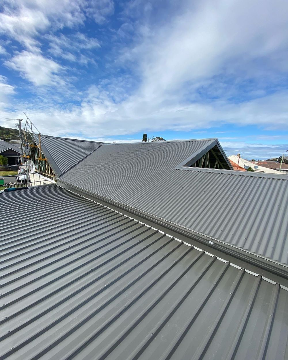A Close Up of a Metal Roof With a Blue Sky in the Background — Lake Valley Roofing in Cardiff, NSW
