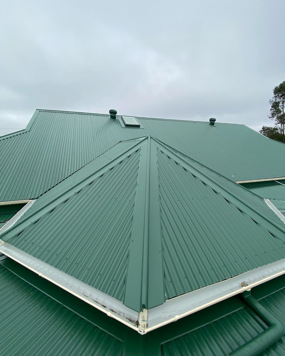 A Green Metal Roof With a White Trim on a House — Lake Valley Roofing in Cardiff, NSW