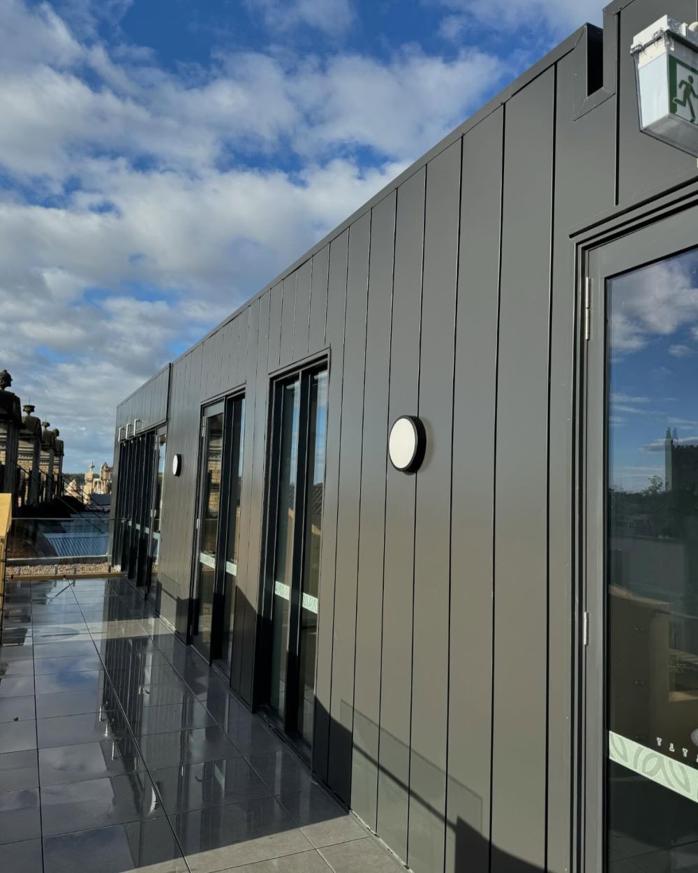 A Large Building With a Lot of Windows and Doors — Lake Valley Roofing in Adamstown, NSW