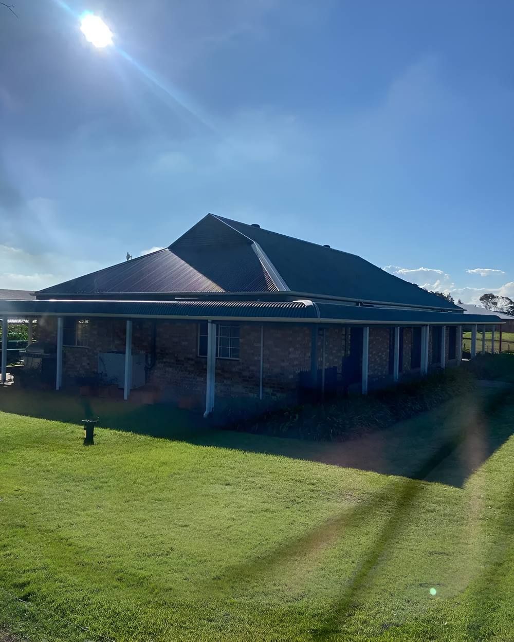 A House With a Covered Porch and a Blue Roof — Lake Valley Roofing in Belmont, NSW