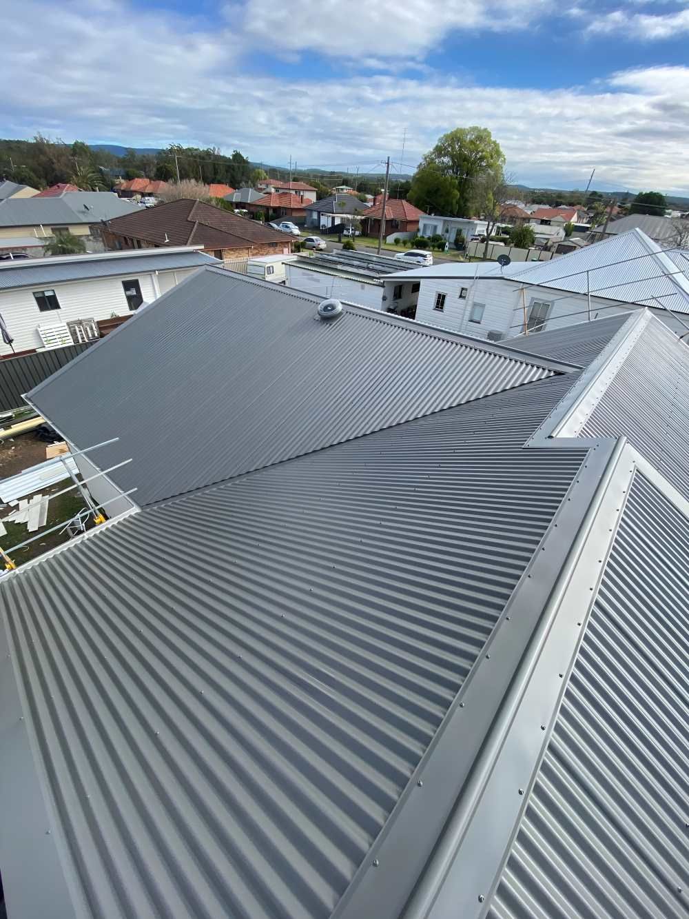 An Aerial View of a House With a Corrugated Metal Roof — Lake Valley Roofing in Kotara, NSW