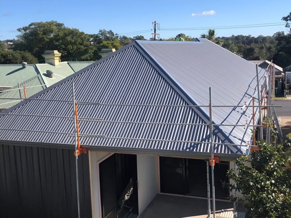 An Aerial View of a House With a Corrugated Metal Roof — Lake Valley Roofing in Maitland, NSW