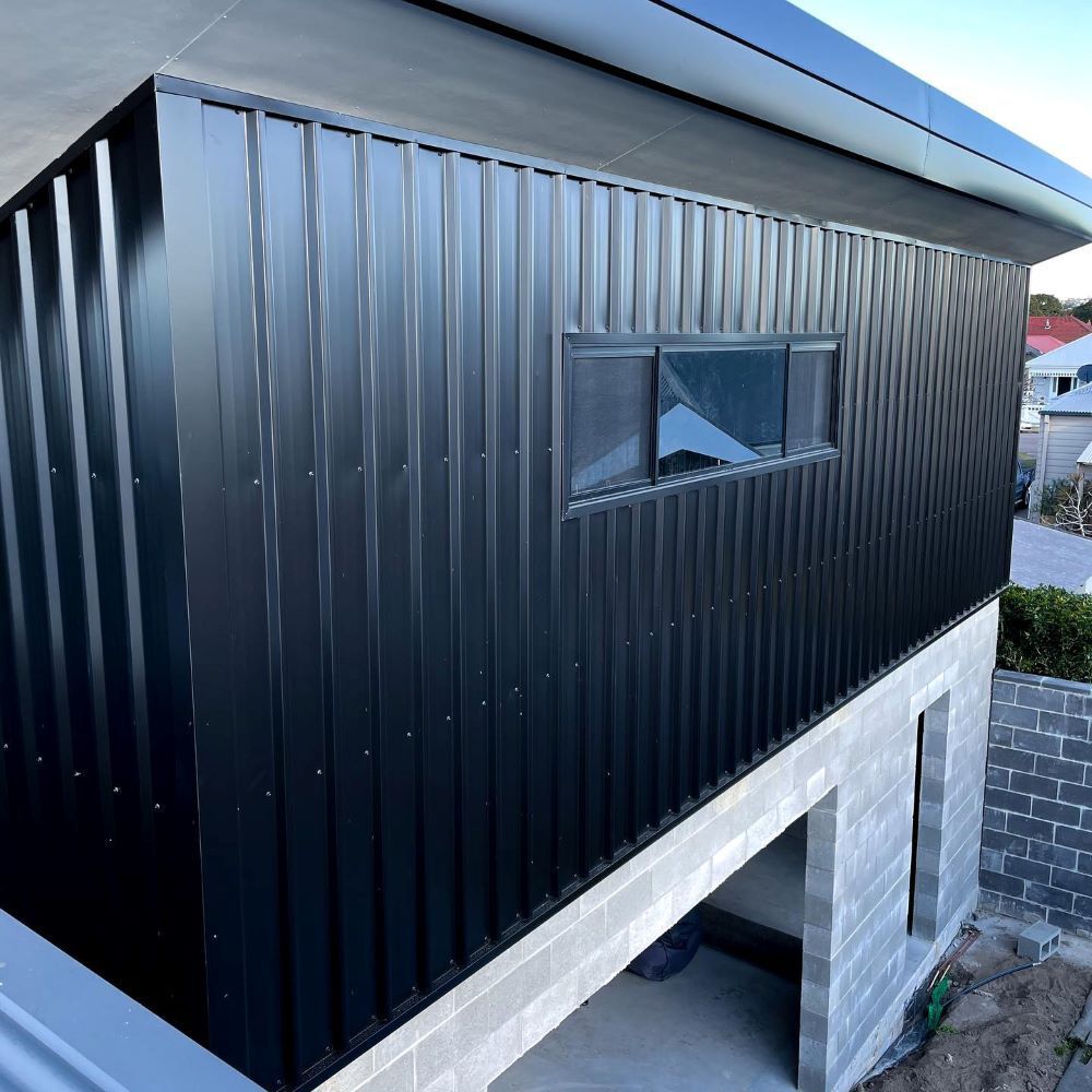 A Black Building With a Window on the Side of It — Lake Valley Roofing in Swansea, NSW