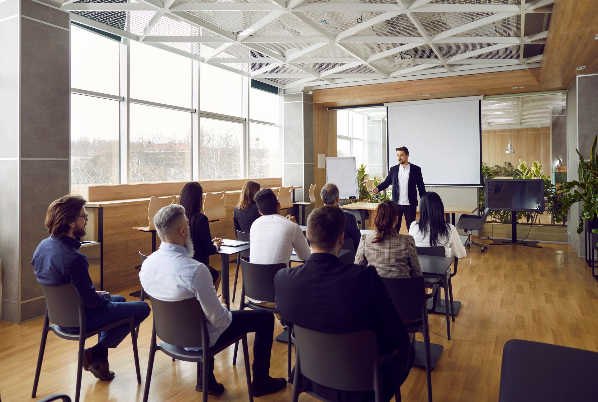 A man is giving a presentation to a group of people in a conference room.