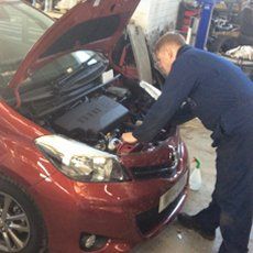 a fully trained mechanic working on repairing the engine of a car